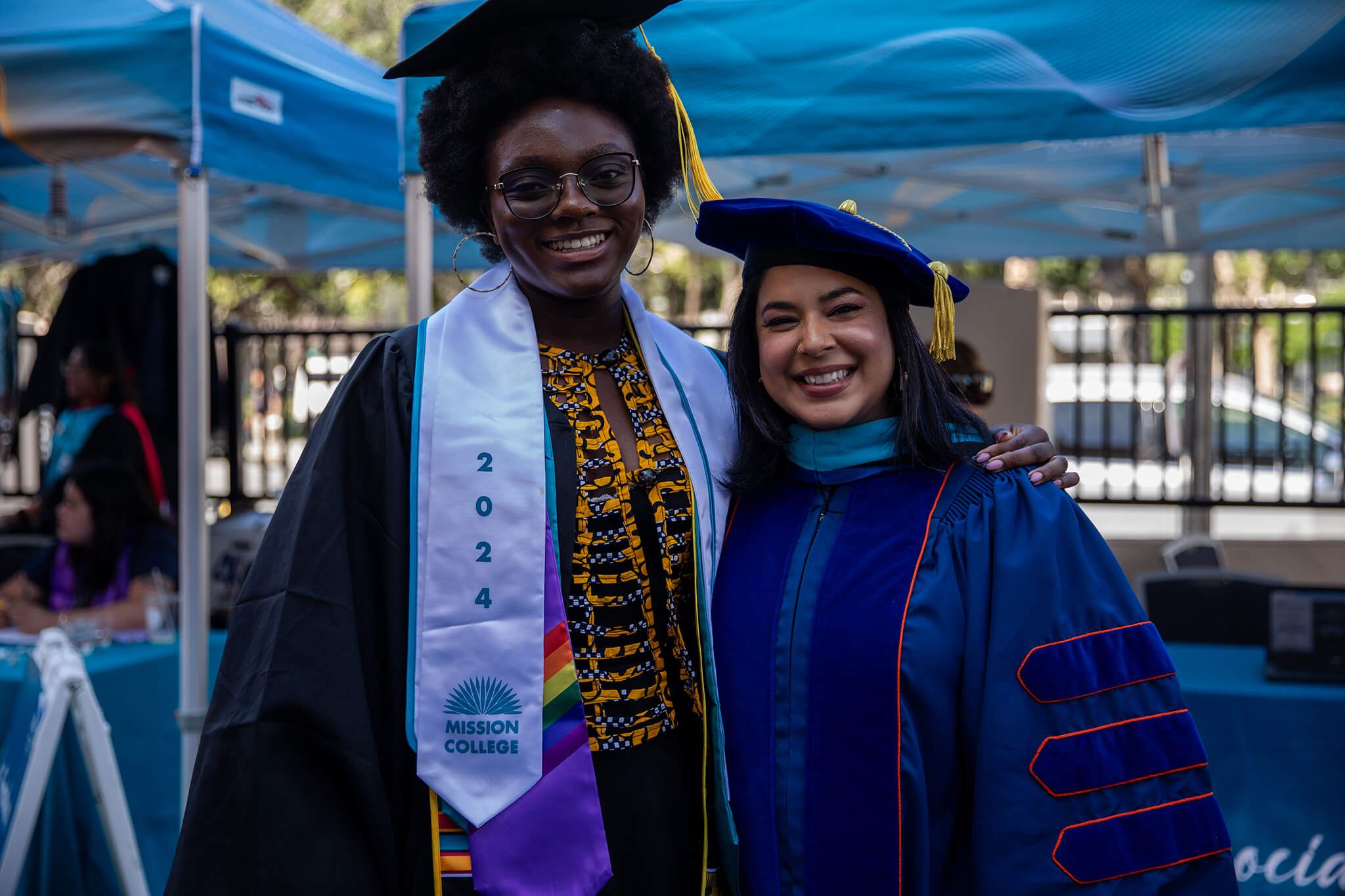 Seher Awan posing for picture with Mission College graduate in commencement robes