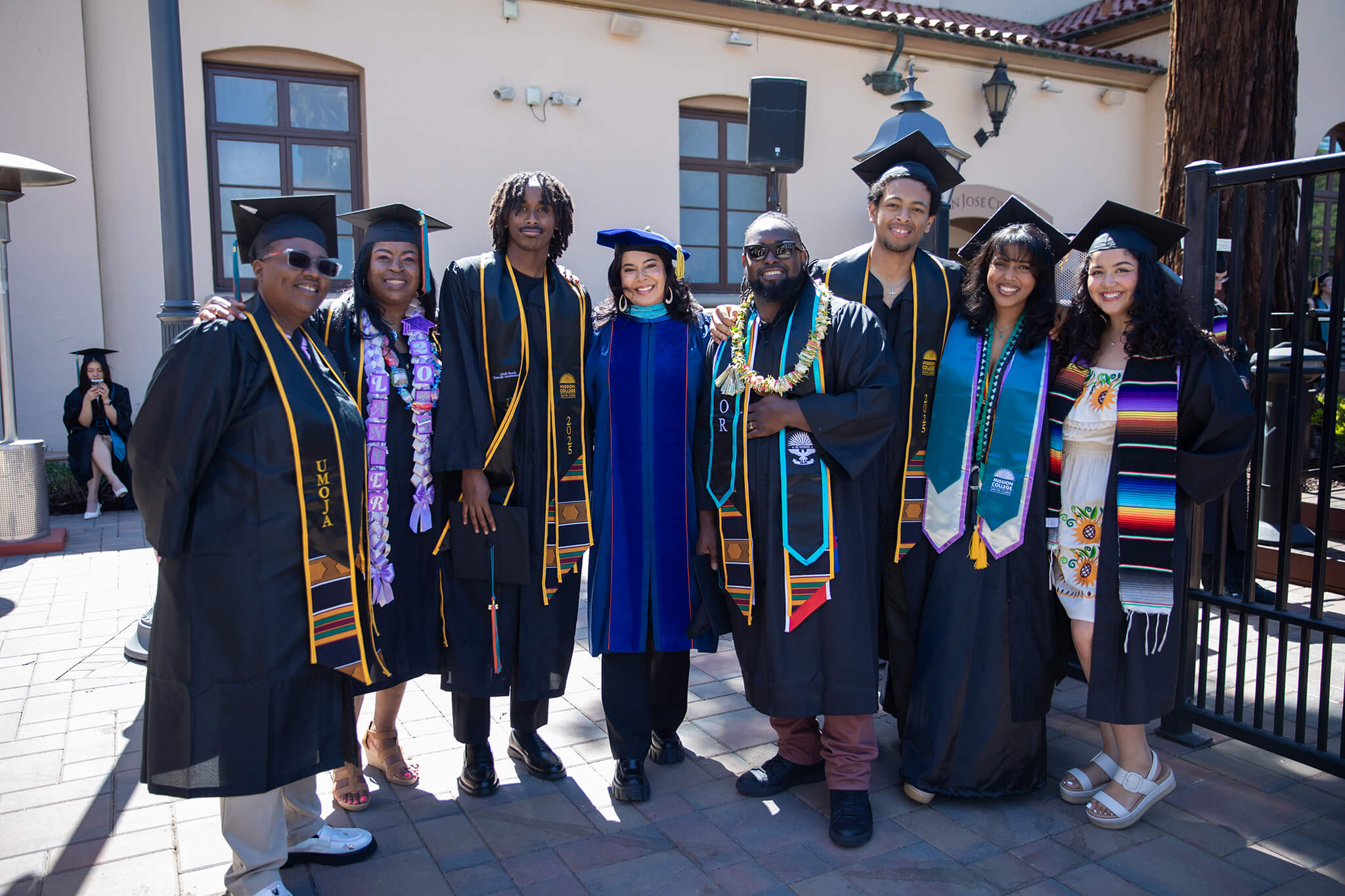 President Seher Awan with Mission College Graduates in their commencement robes