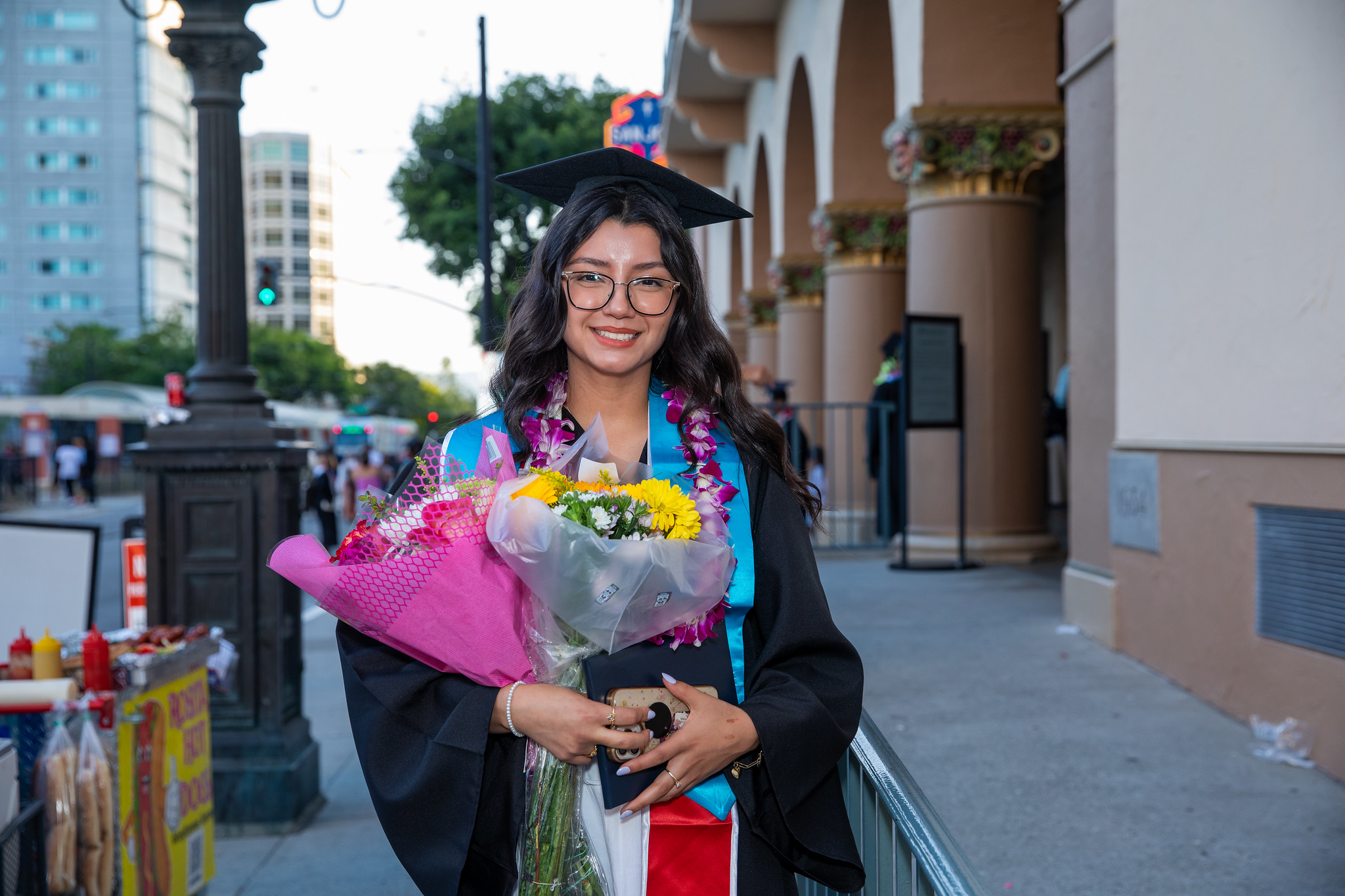 Mission College graduate holding flowers